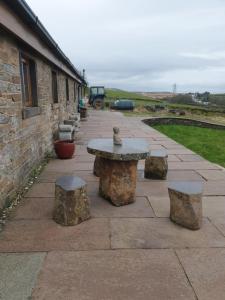 a stone patio with a table and some rocks at The Coach House 