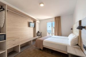 a hotel room with a bed and a window at Hotel Queens - Adults Only in Benidorm