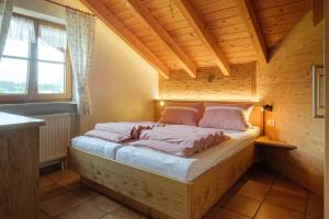 1 dormitorio con 1 cama en una casa de madera en Gästehaus Mooswiese en Ofterschwang