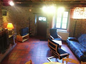 a living room with a couch and a tv at Lovely Holiday Home in Treignes with Garden in Treignes