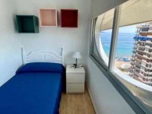 sypialnia z łóżkiem i dużym oknem w obiekcie Apartamento turístico Playmon Bacana Planta 13 w mieście Benidorm