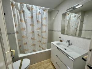 łazienka z umywalką i zasłoną prysznicową w obiekcie Apartamento turístico Playmon Bacana Planta 13 w mieście Benidorm