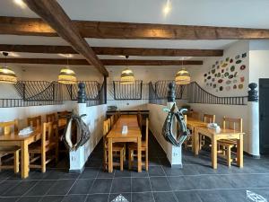 una sala da pranzo con tavoli e sedie in legno di Gîtes dans Domaine des Barrettes ad Agde