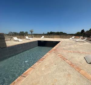 una piscina con sedie a sdraio in acqua di Gîtes dans Domaine des Barrettes ad Agde