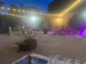 una tenda con luci, tavoli e sedie di notte di Gîtes dans Domaine des Barrettes ad Agde