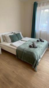 a bedroom with a large bed with towels on it at Night & Flight Airport Apartman in Vecsés