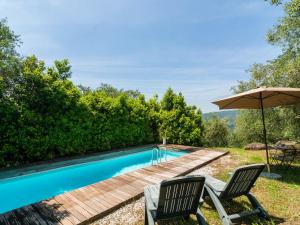 UzzanoにあるIdyllic Holiday Home in Pescia with Swimming Poolのスイミングプール(椅子2脚、パラソル付)