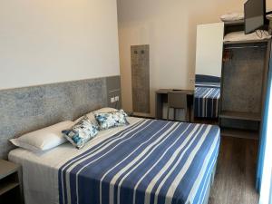 a bedroom with a bed with blue and white sheets and pillows at Real Park Hotel in Cavi di Lavagna