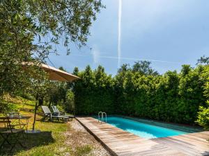 UzzanoにあるIdyllic Holiday Home in Pescia with Swimming Poolの木製デッキ付きの庭のスイミングプール