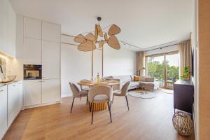 a kitchen and living room with a table and chairs at Baltica Residence - Premium Apartments in Gdańsk