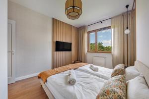 a bedroom with a bed and a tv on a wall at Baltica Residence - Premium Apartments in Gdańsk