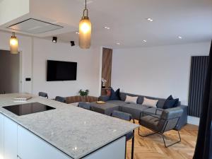 a kitchen and living room with a couch and a table at Newly Renovated Flat with Parking space in Canterbury