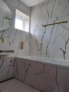 a bathroom with marble walls and a window at Newly Renovated Flat with Parking space in Canterbury