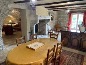 a dining room with a table and a fireplace at Gites au Château des Estubiers in Les Granges-Gontardes
