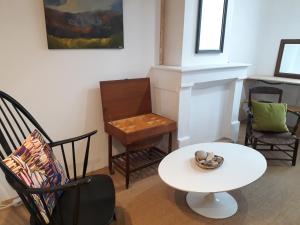 uma sala de estar com uma mesa branca e cadeiras em La Marginale em Fontevraud L'Abbaye