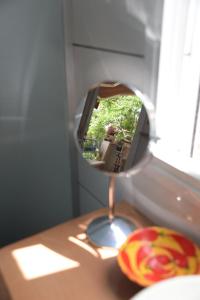 un miroir assis au-dessus d'une table en bois dans l'établissement Bialik St B&B room Bauhaus district Tel Aviv, à Tel Aviv