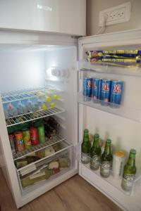 an open refrigerator filled with lots of drinks and soda at Bialik St B&B room Bauhaus district Tel Aviv in Tel Aviv