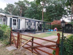 a house with a wooden fence in front of it at BPW 1105 - Bospark t Wolfsven in Mierlo