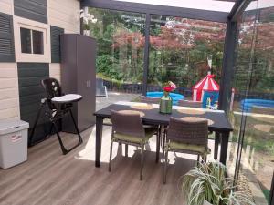 a patio with a table and chairs and a playground at BPW 1105 - Bospark t Wolfsven in Mierlo