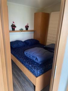 een klein bed met blauwe kussens in een kamer bij BPW 1105 - Bospark t Wolfsven in Mierlo