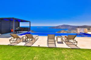 a group of chairs sitting on a patio with a view of the ocean at Luxury Sea View Villa w Pool Near Beach in Kalkan in Kalkan