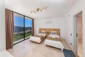 a bedroom with two beds and a large window at Luxury Sea View Villa w Pool Near Beach in Kalkan in Kalkan