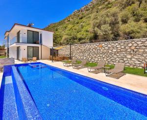 a villa with a swimming pool and a house at Luxury Sea View Villa w Pool Near Beach in Kalkan in Kalkan