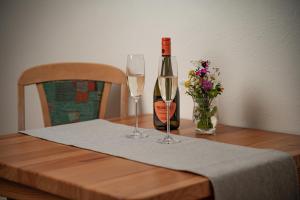 een fles wijn en twee glazen op een tafel bij Horský Hotel Totem in Jarabá