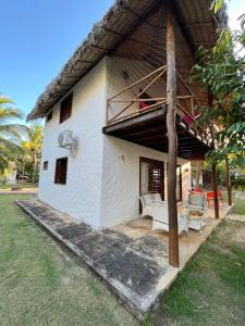 a house with a porch with a couch and a chair at Bangalôs da Barra Chalé 3 in Barra Grande