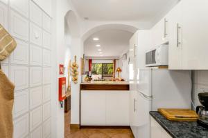 a kitchen with white cabinets and a sink at Pine Trees Penthouse in Olhos de Água