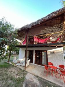 a house with red chairs and a table and chairs at Bangalôs da Barra Chalé 3 in Barra Grande