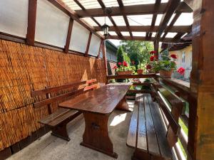 a wooden table and benches on a patio at Casa Tofalvi in Sovata