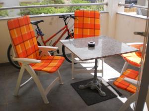 a table and chairs on a balcony with a bike at Apartment Sun in Novalja