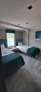 a bedroom with two beds and a window in it at Hotel Plutitor Lebăda in Bicaz +140 photos