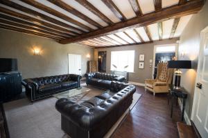 een woonkamer met leren banken en een televisie bij Great Blunts House - Stock Brook Manor Golf Club in Stock