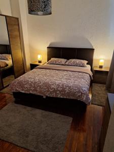 - une chambre avec un lit, deux lampes et un miroir dans l'établissement Apartman EL, à Sarajevo