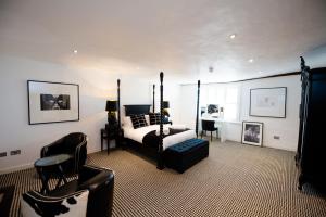 een slaapkamer met een bed, een tafel en stoelen bij Great Blunts House - Stock Brook Manor Golf Club in Stock