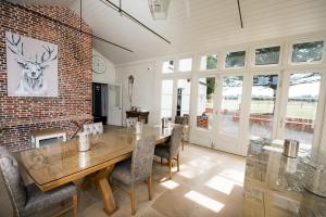 een eetkamer met een bakstenen muur en een tafel en stoelen bij Great Blunts House - Stock Brook Manor Golf Club in Stock