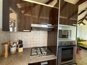 a kitchen with a stove top oven in a kitchen at O'coco Bungalow in Paea