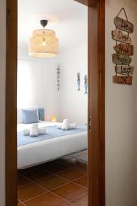 a bedroom with a bed and a sign on the wall at Seagulls' House in Nazaré