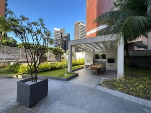 a patio with a table and a palm tree at Helbor My Way - Compactos de luxo in Fortaleza