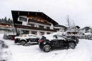 two cars parked in the snow in front of a building at Mountainlodge Tirol Berwang in Berwang
