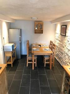 a kitchen with a table with chairs and a refrigerator at Ferienwohnung Felinenhof in Weilerswist +17 photos