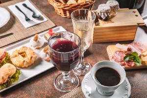 uma mesa com um prato de comida e um copo de vinho em Pousada Cantelli em Bento Gonçalves