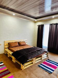 a bedroom with a wooden bed in a room at Orgventure Resorts Skardu in Skardu