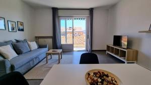 ein Wohnzimmer mit einem blauen Sofa und einem Tisch in der Unterkunft Milano Apartment in Triest