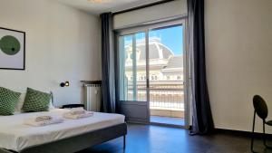 Schlafzimmer mit einem Bett und einer großen Glastür in der Unterkunft Milano Apartment in Triest