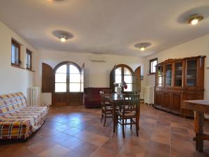 a living room with a table and chairs and a couch at Cosy agriturismo in Toscana with outdoor swimming pool in Peccioli