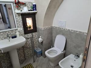 La salle de bains est pourvue de toilettes blanches et d'un lavabo. dans l'établissement Tourist House La Castellana, à Catane