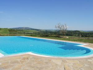 a large swimming pool with blue water in a yard at Cosy agriturismo in Toscana with outdoor swimming pool in Peccioli